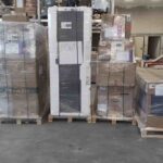 multiple large pallets wrapped in plastic film organized in warehouse area
